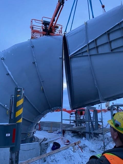 Local 512 members rigging a large fabricated duct transition with a crane at dusk
