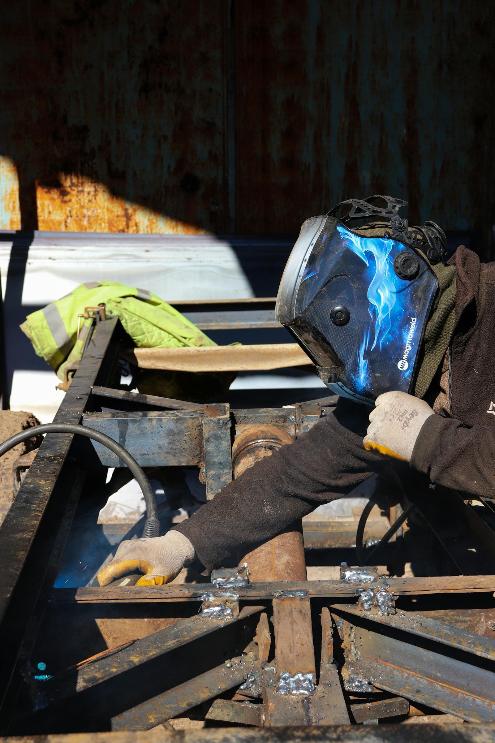 Sheet metal worker welding on a steel frame